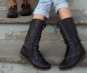 Kids sitting on porch, only their shoes is seen